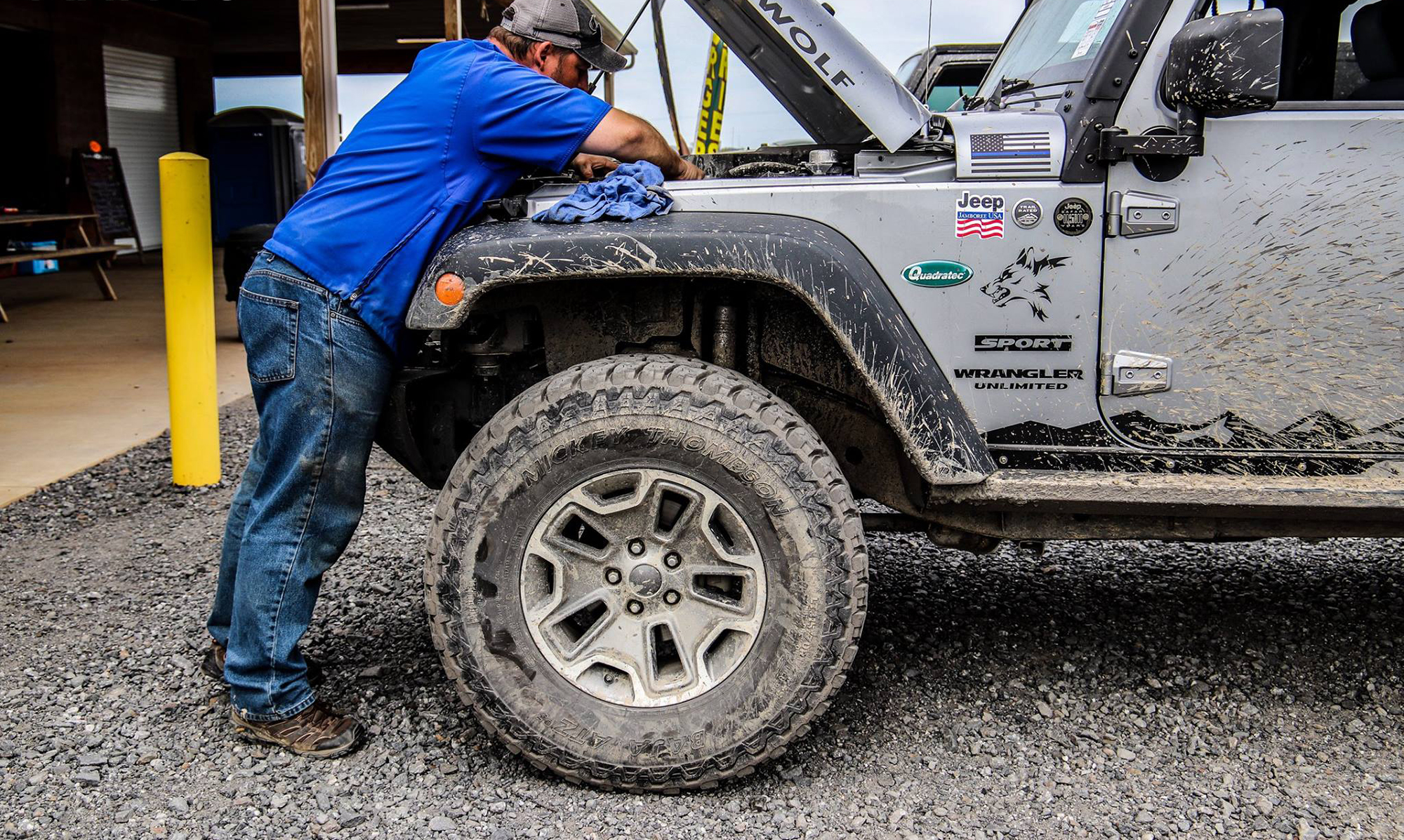 Man working on a gray Jeep