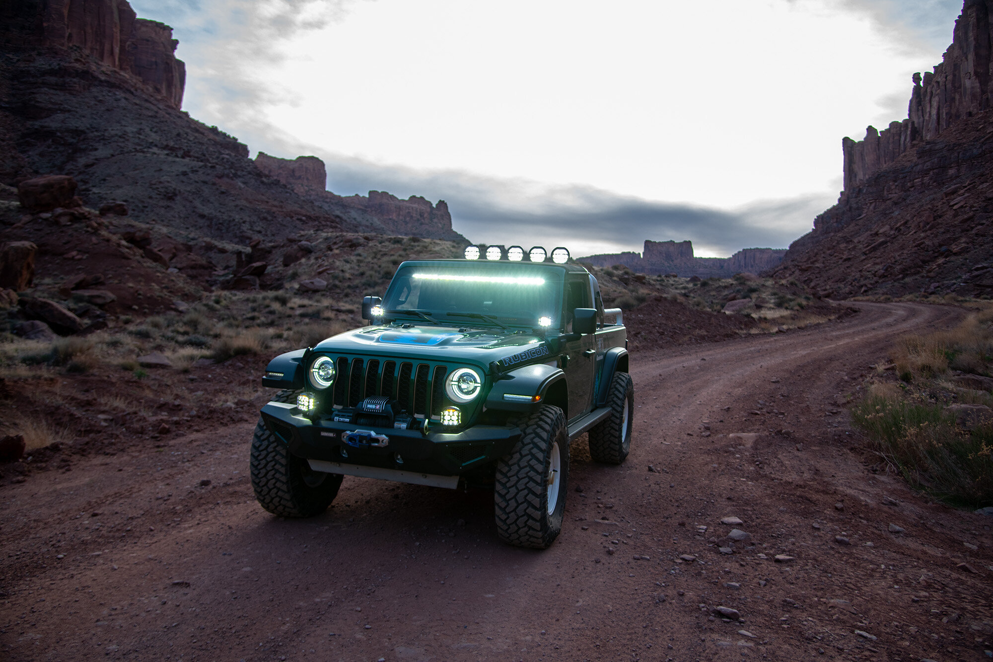 Green Jeep Gladiator with desert red background