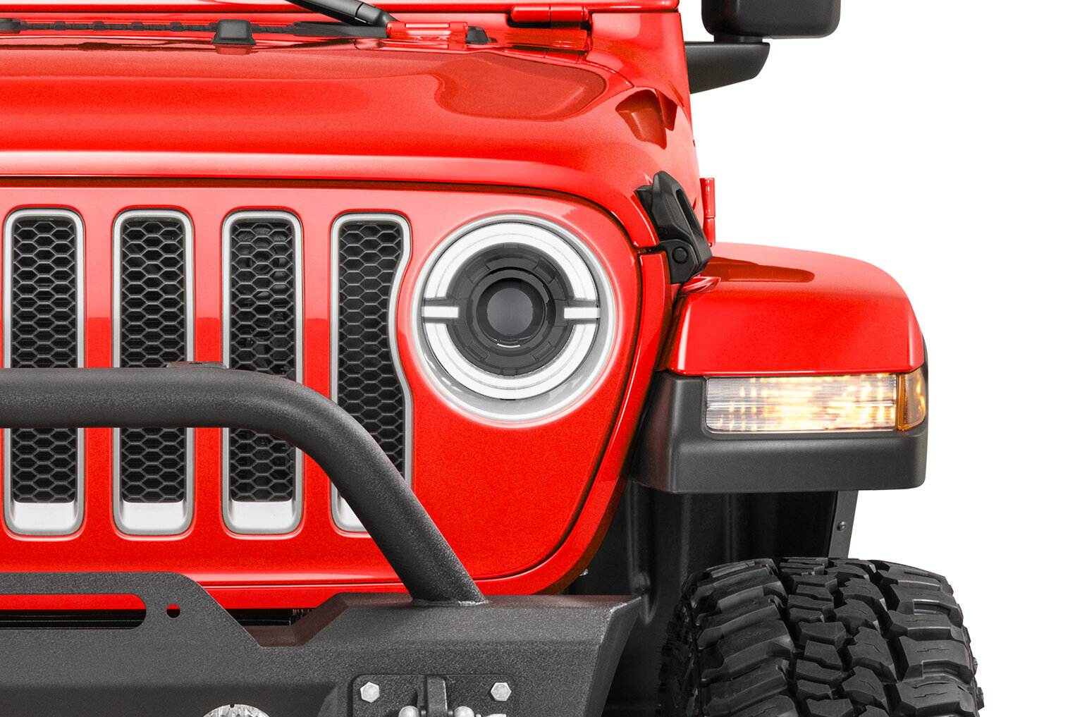 The front grille and headlight of a red Jeep Wrangler