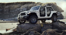White Jeep Wrangler on a rock with a rocky and watery background