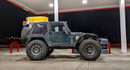 Green two-door Wrangler at a gas station