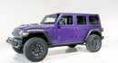 Purple four-door Jeep Wrangler with a white background.