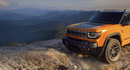 Orange Jeep Recon with a mountain background