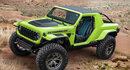 Green and black Jeep against a rocky background