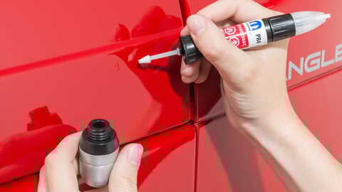 Mopar Touch Up Paint Pen being used on a red Jeep Wrangler.