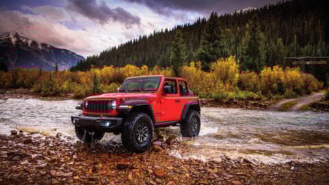 Red Jeep crossing a river