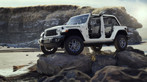 White Jeep Wrangler on a rock with a rocky and watery background