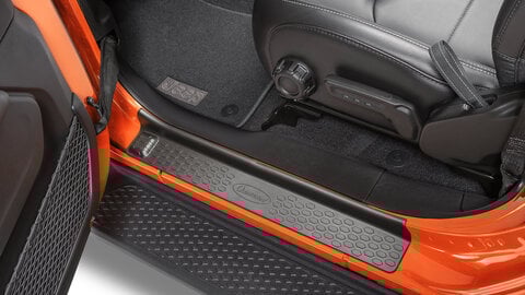 Jeep thermoplastic entry guards installed on an orange Jeep Wrangler