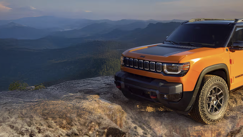Orange Jeep Recon with a mountain background
