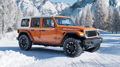 Orange Jeep on a snowy road with a mountain background
