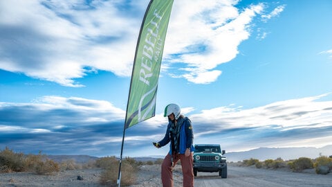 Rebelle Rally competitor checking a gps location next to an event flag