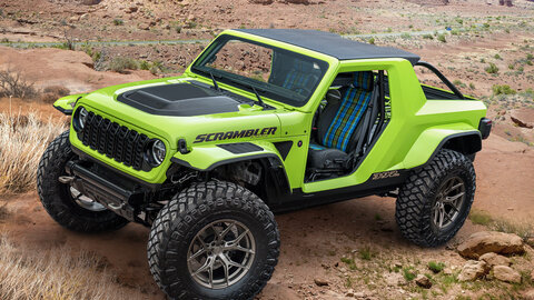 Green and black Jeep against a rocky background